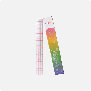 Roll of grid paper next to a colorful packaging box on a white background